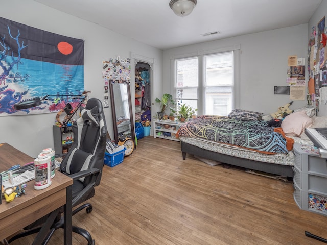 bedroom featuring visible vents and wood finished floors