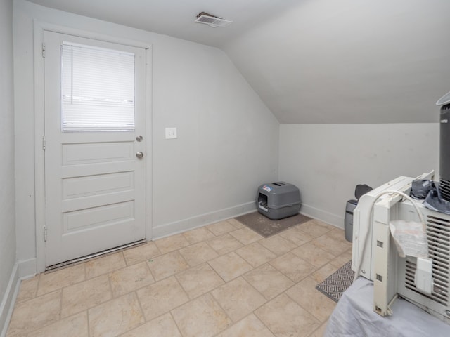 interior space with visible vents, vaulted ceiling, and baseboards