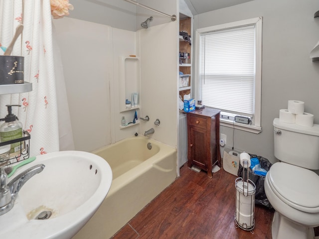 bathroom with shower / bath combination, toilet, a sink, and wood finished floors