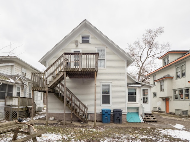 rear view of property with entry steps and a wooden deck