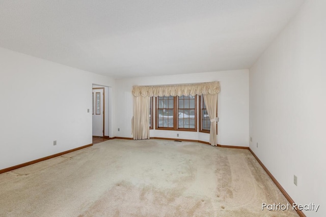 carpeted empty room with baseboards