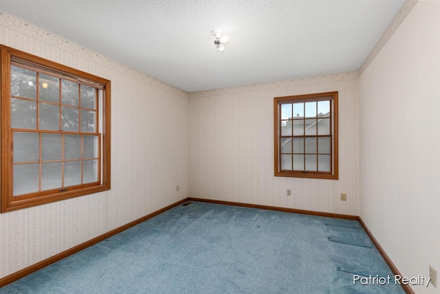 unfurnished room featuring baseboards, a textured ceiling, carpet, and wallpapered walls