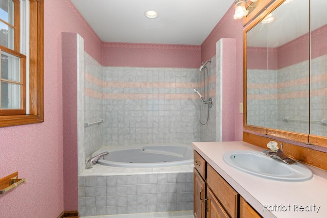 full bathroom with a jetted tub and vanity