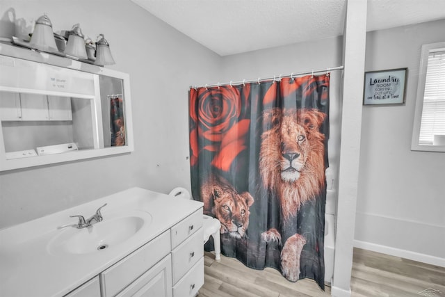 bathroom featuring a textured ceiling, wood finished floors, vanity, and a shower with curtain