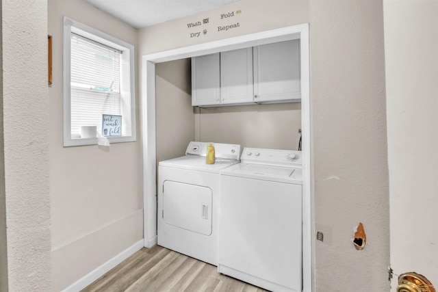 washroom with light wood-style floors, cabinet space, baseboards, and separate washer and dryer