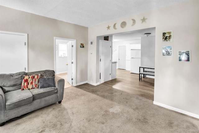 carpeted living room with baseboards and a textured ceiling