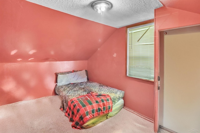 carpeted bedroom featuring lofted ceiling and a textured ceiling