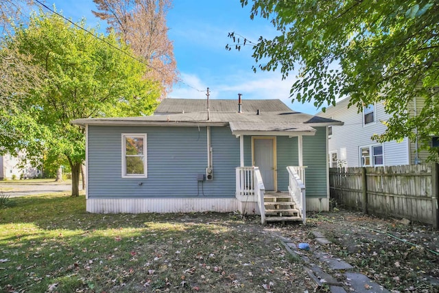 back of house featuring a lawn and fence