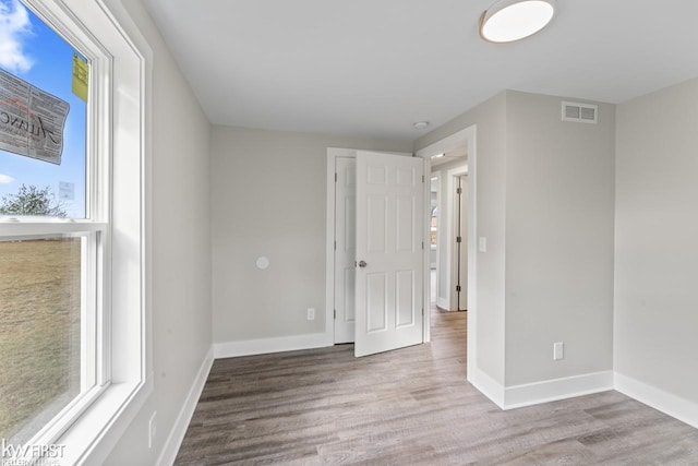 unfurnished bedroom with visible vents, baseboards, and wood finished floors