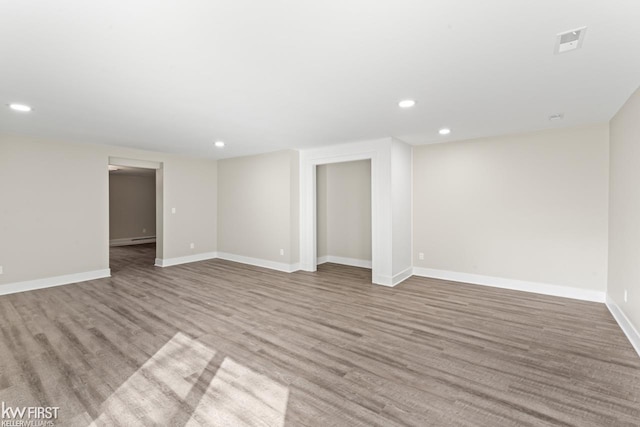 interior space with baseboards, wood finished floors, and recessed lighting