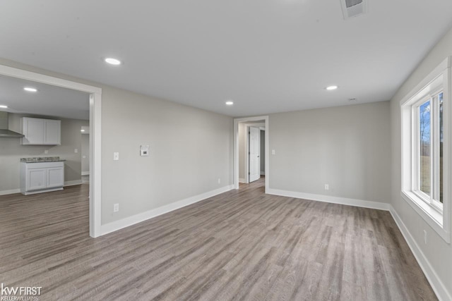 unfurnished living room featuring light wood-style floors, recessed lighting, visible vents, and baseboards