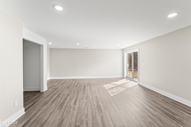 spare room featuring recessed lighting, baseboards, and wood finished floors