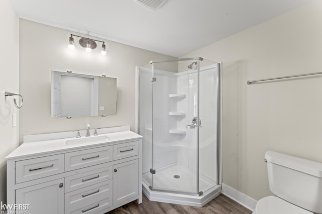 bathroom with toilet, a shower stall, visible vents, and wood finished floors