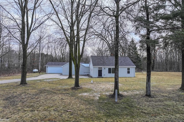 view of front of house with a shingled roof, a front lawn, and an outbuilding