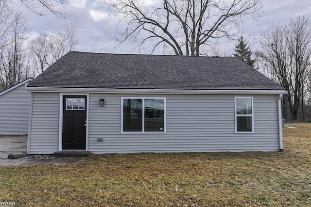 exterior space with a front lawn and roof with shingles