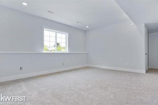 spare room with recessed lighting, carpet flooring, visible vents, and baseboards