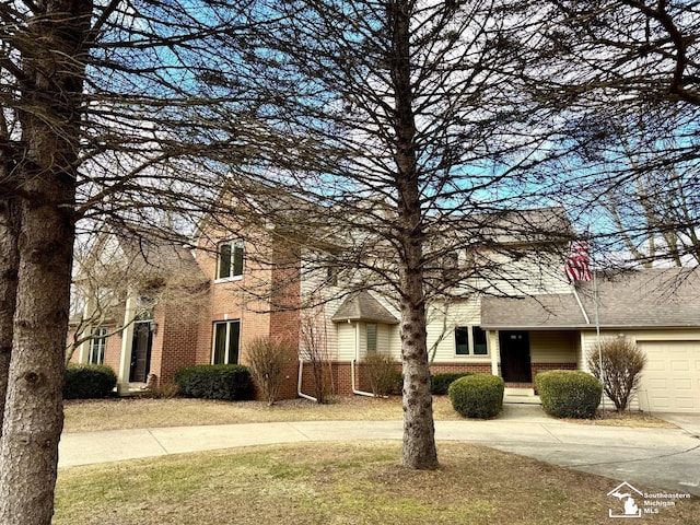 view of front of house featuring driveway, brick siding, a front lawn, and an attached garage