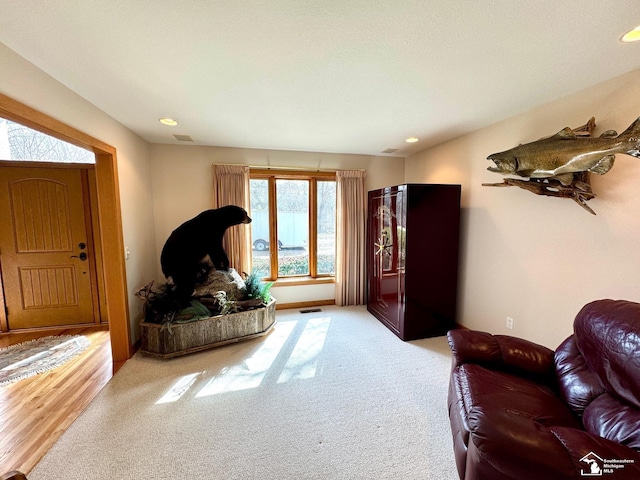 living room featuring carpet, visible vents, and recessed lighting