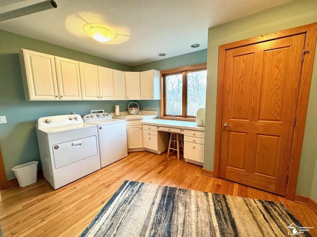 laundry area with light wood-type flooring, cabinet space, baseboards, and independent washer and dryer