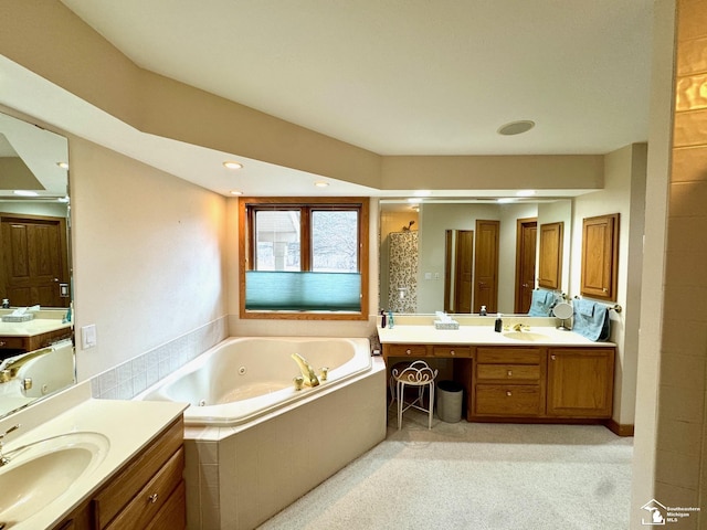 full bathroom featuring a whirlpool tub, two vanities, a sink, and recessed lighting