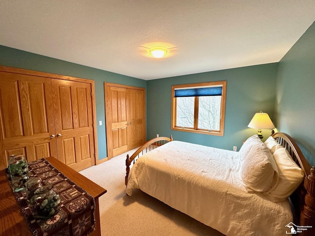 carpeted bedroom featuring multiple closets