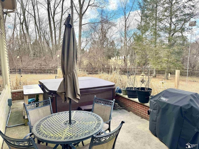 view of patio with outdoor dining space, grilling area, and a hot tub