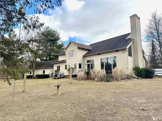 back of property featuring a yard and a chimney