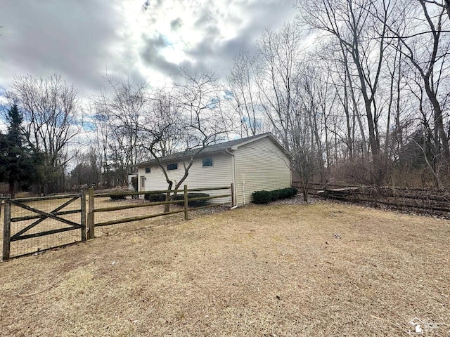 view of side of home featuring a gate and fence