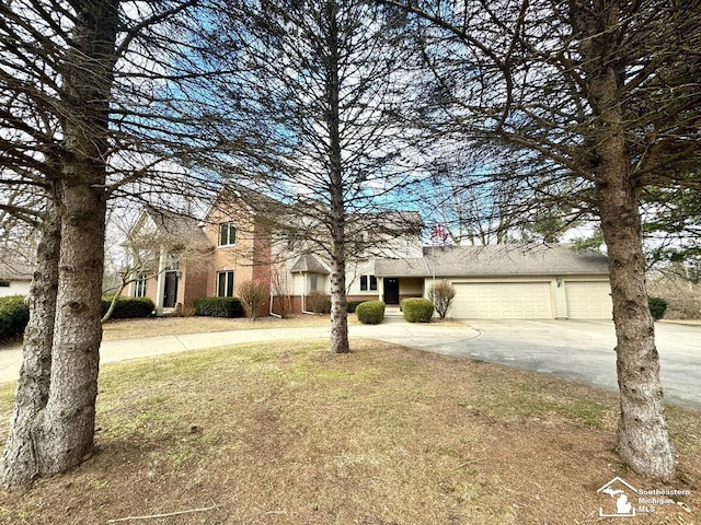 traditional-style home with driveway, brick siding, and an attached garage