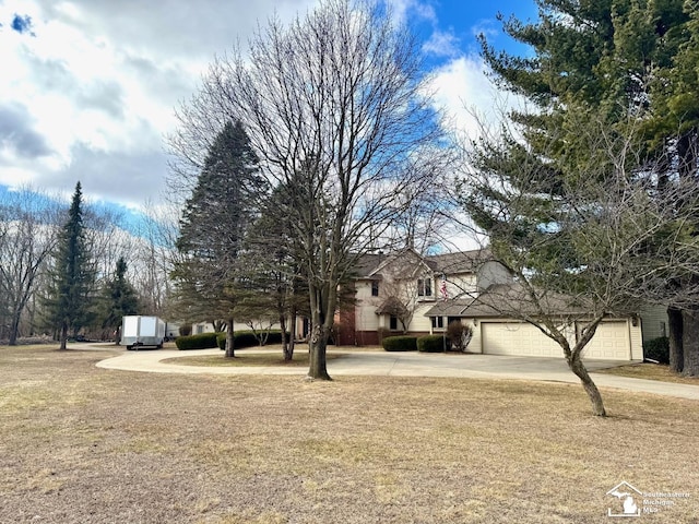 view of yard featuring concrete driveway and an attached garage