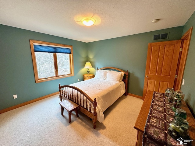 carpeted bedroom featuring visible vents, a textured ceiling, and baseboards