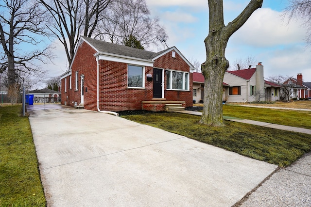 bungalow-style home with a front lawn and brick siding