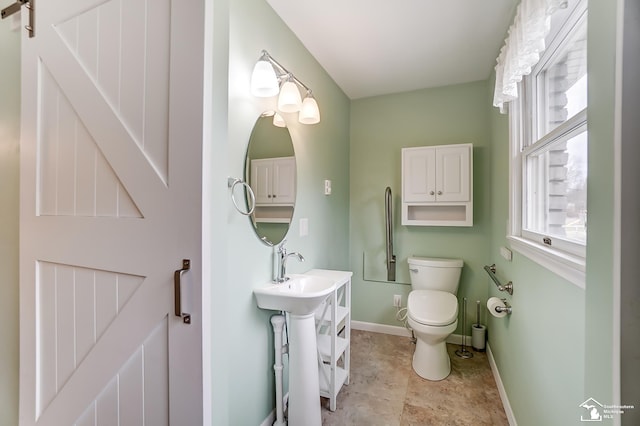 half bath featuring toilet and baseboards