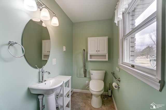 half bathroom featuring toilet and baseboards