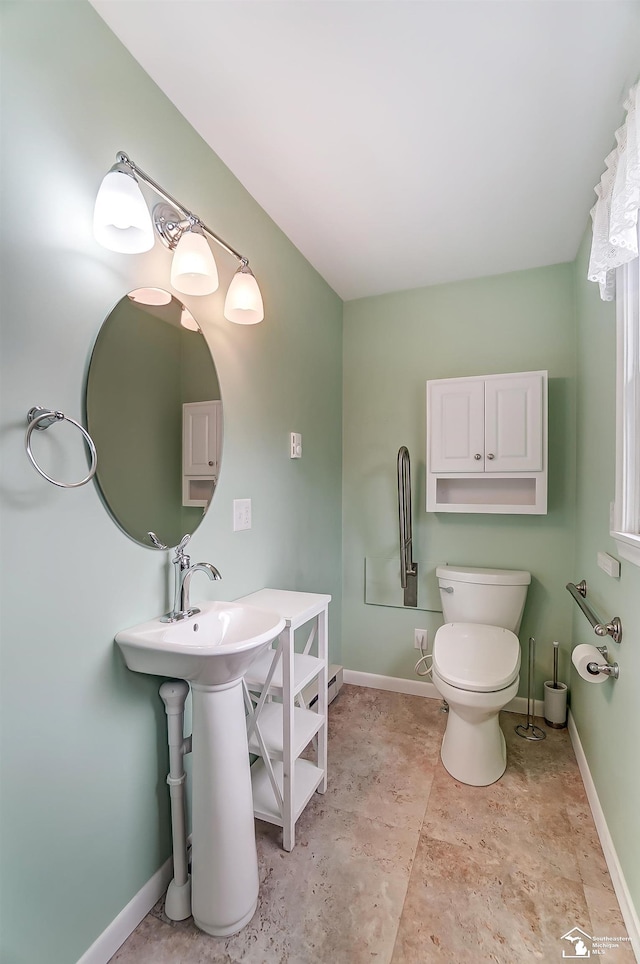 half bathroom featuring toilet and baseboards