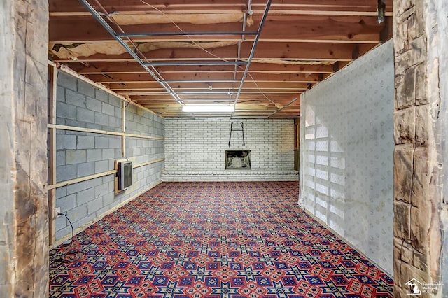 unfinished below grade area featuring electric panel and tile patterned floors