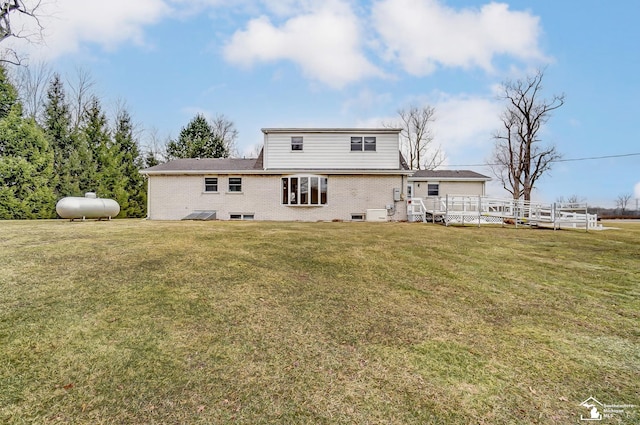 back of property with brick siding, a deck, and a yard