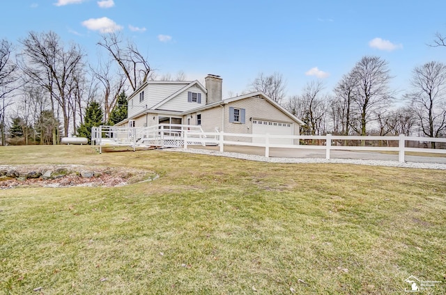 view of front of property featuring a fenced front yard, a front yard, a chimney, and a garage