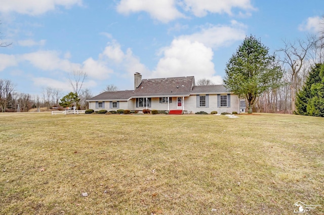 view of front of house featuring a chimney and a front yard