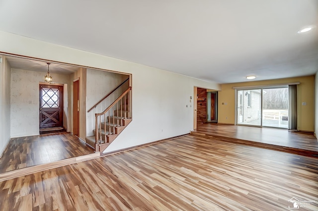 interior space with light wood finished floors, stairs, and baseboards