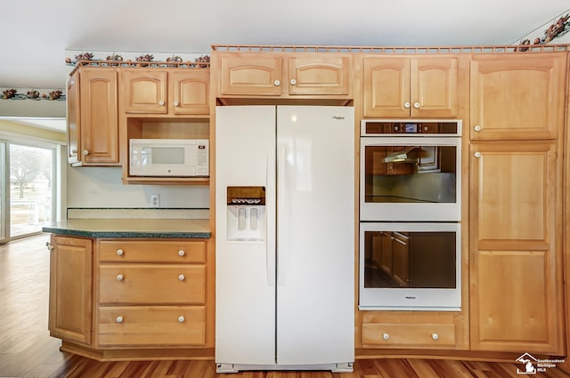 kitchen featuring wood finished floors, white appliances, dark countertops, and light brown cabinets