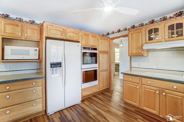 kitchen with glass insert cabinets, ceiling fan, wood finished floors, white appliances, and under cabinet range hood