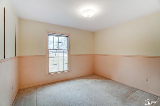 unfurnished room featuring carpet and baseboards