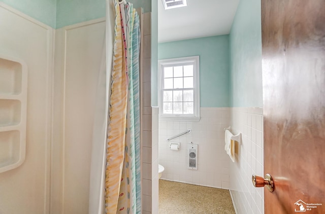 bathroom with tile walls, curtained shower, visible vents, toilet, and wainscoting