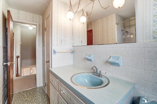 bathroom featuring a wainscoted wall, tile walls, vanity, and wallpapered walls