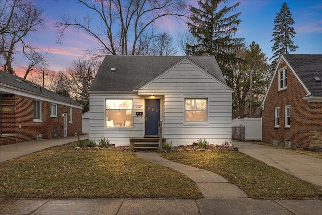 bungalow featuring a shingled roof and fence