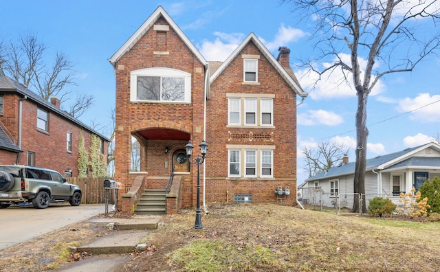 2412 Cornell St, Dearborn, MI 48124 - view of front of home featuring driveway, brick siding, a chimney, and fence