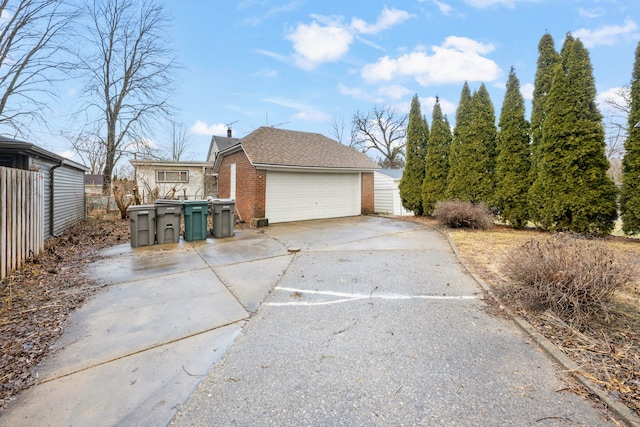 2412 Cornell St, Dearborn, MI 48124 - view of home's exterior with a garage, brick siding, fence, and roof with shingles