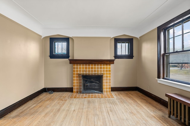 2412 Cornell St, Dearborn, MI 48124 - unfurnished living room featuring baseboards, radiator, hardwood / wood-style floors, and a healthy amount of sunlight