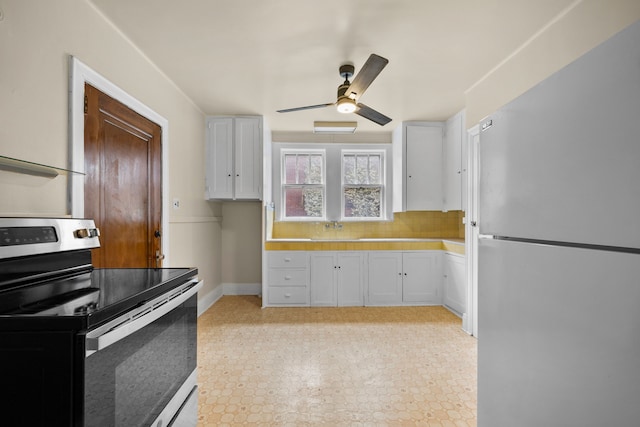 2412 Cornell St, Dearborn, MI 48124 - kitchen featuring ceiling fan, appliances with stainless steel finishes, light floors, white cabinetry, and backsplash